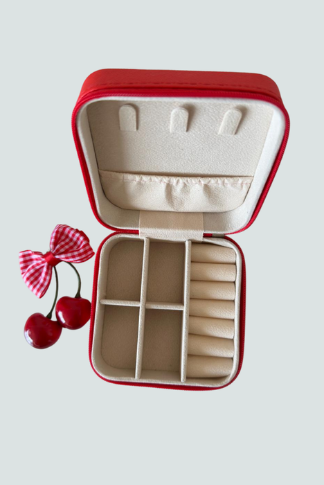 Joyero rojo abierto con espacios para anillos y collares